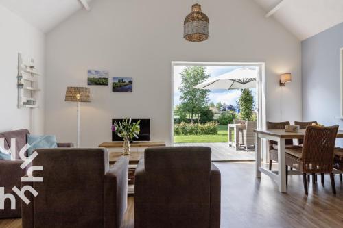 a living room with a table and chairs and an umbrella at OV072 Exklusives 4P-Ferienhaus in bester Lage in Giethoorn in Giethoorn