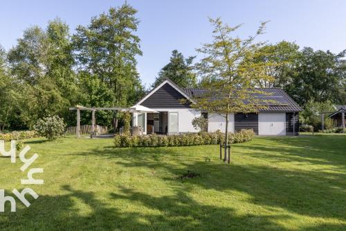 a small house in a yard with a tree at OV072 Exklusives 4P-Ferienhaus in bester Lage in Giethoorn in Giethoorn