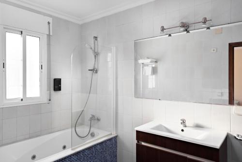 ein weißes Badezimmer mit Dusche und Waschbecken in der Unterkunft Suites Cortijo Fontanilla in Conil de la Frontera