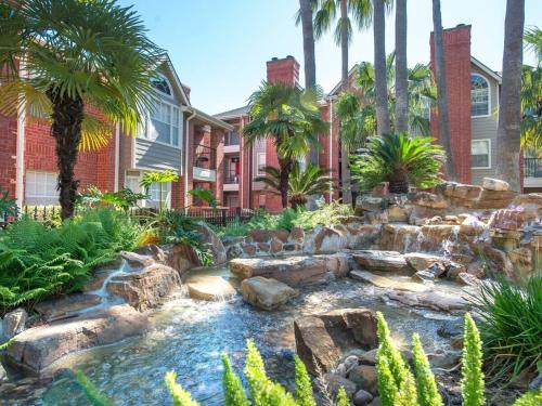a garden with a waterfall in front of a house at Med Center Charm 2br Haven in Houston