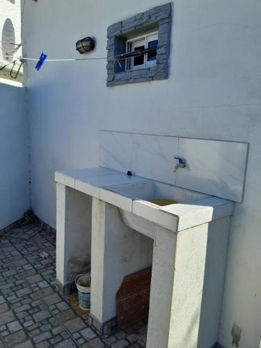 a concrete sink with a window on a white wall at La lechon in Santa Teresita