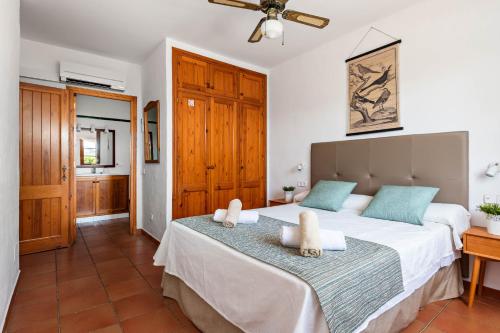 a bedroom with a large bed with two towels at Villas Playas de Fornells in Fornells