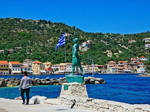 a woman standing next to a statue next to the water at Villa Thea Antonis in Gaios