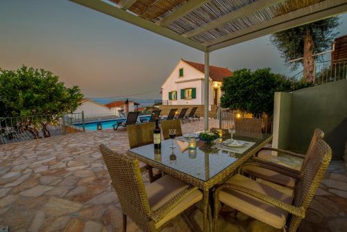 a dining table and chairs on a patio at Villa Thea Antonis in Gaios
