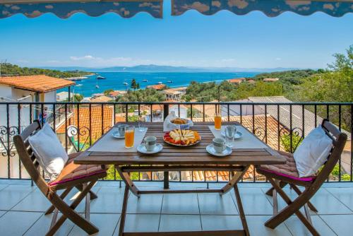 a wooden table with a plate of food on a balcony at Villa Thea Antonis in Gaios