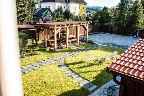 a backyard with a gazebo and two chairs at Apartmány ZeMě in Nové Město pod Smrkem