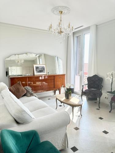 - un salon avec deux canapés blancs et un piano dans l'établissement Appartements de Luxe Bord de Mer, à Roquebrune-Cap-Martin