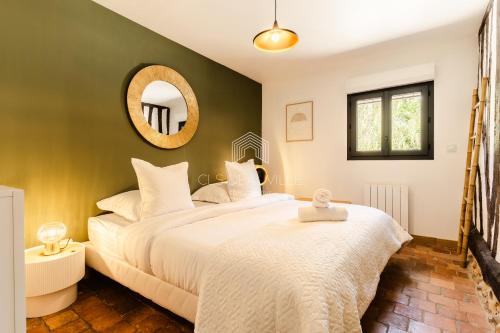 une chambre avec un grand lit et un miroir dans l'établissement Domaine de Syrka à Deauville, à Saint-Étienne-la-Thillaye