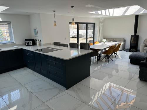 a kitchen and living room with a table and chairs at PARK VIEW, 6 bed family home, wifi parking, garden in Kettering