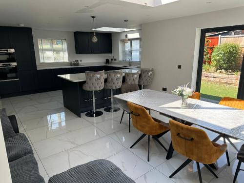 a kitchen with a large table and chairs at PARK VIEW, 6 bed family home, wifi parking, garden in Kettering