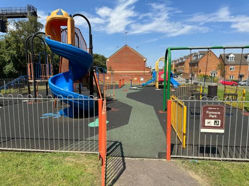 a playground with a slide in a park at PARK VIEW, 6 bed family home, wifi parking, garden in Kettering