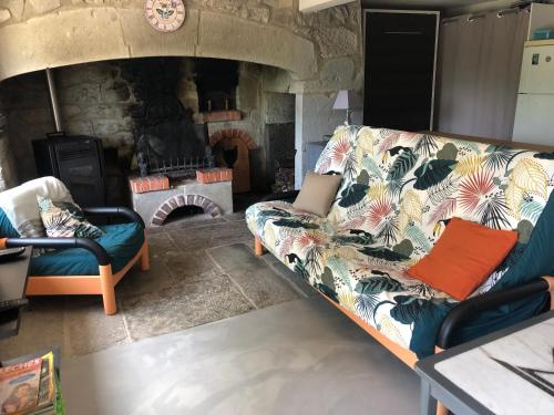 a living room with a couch and a stone fireplace at studio du clarel in Araules