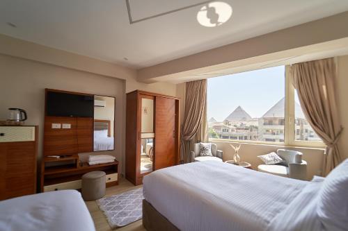 prestige pyramids INN في القاهرة: غرفة فندقية بسرير ونافذة كبيرة