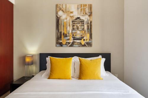a bedroom with a bed with yellow pillows at La Buena Vida Holiday Homes - Modern, Luxe & Spacious 4-Bed, Full Kitchen, near to Beach, Tram & Marina in Dubai
