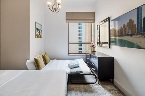 a bedroom with a bed and a desk and a window at La Buena Vida Holiday Homes - Modern, Luxe & Spacious 4-Bed, Full Kitchen, near to Beach, Tram & Marina in Dubai