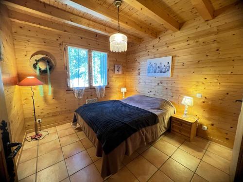 une chambre avec un lit dans une cabane en bois dans l'établissement Murgiers B1 - Chalet mitoyen, à La Clusaz