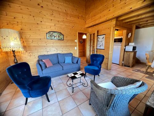 un salon avec un canapé bleu et des chaises dans l'établissement Murgiers B1 - Chalet mitoyen, à La Clusaz