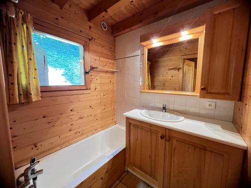 une salle de bain avec une baignoire et un lavabo et une baignoire tubermottermott dans l'établissement Murgiers B1 - Chalet mitoyen, à La Clusaz