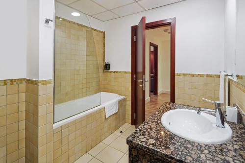 a bathroom with a sink and a bath tub at La Buena Vida Holiday Homes - Modern, Luxe & Spacious 4-Bed, Full Kitchen, near to Beach, Tram & Marina in Dubai