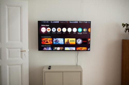 a flat screen tv hanging on a wall at Hip & Beautiful City Apartment in Berlin