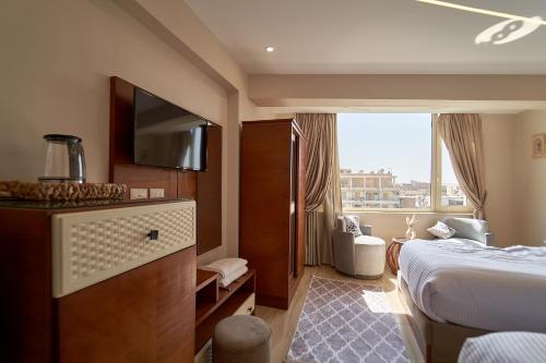 a hotel room with a bed and a television at prestige pyramids INN in Cairo