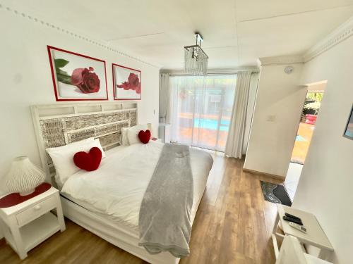 a bedroom with a bed with two red hearts on it at FM GUEST LODGE Comfort, Tranquility & Peace of Mind in Johannesburg