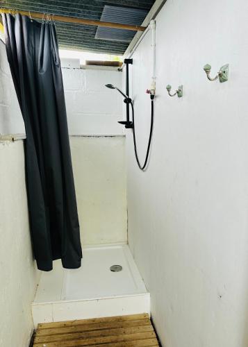 a shower with a black shower curtain in a room at Yule Tree Campsite in Helston