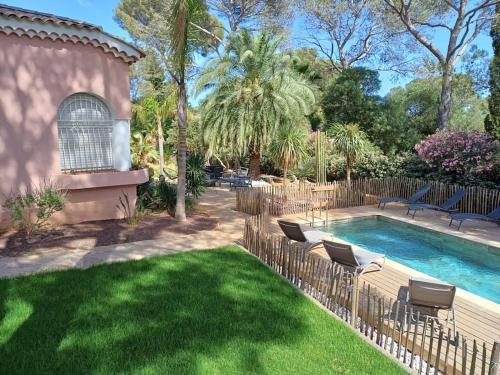 une cour avec une piscine et des chaises à côté d'une cour dans l'établissement Villa avec Piscine à 300m de la plage a la Croix Valmer, à La Croix-Valmer