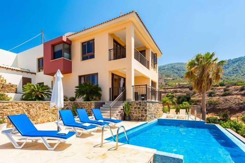 a villa with a swimming pool and a house at Mermaid Villa in Pomos