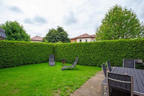 a garden with chairs and a table and a hedge at sennefeeling in Hövelhof