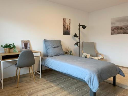 a bedroom with a bed and a desk at HMS16 I 1-Zimmer Apartment mit Balkon I Daimler Nähe I S-Bahn & City - Sindelfingen in Sindelfingen