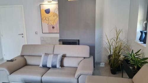 a white couch in a living room with plants at VAL22,VILLA 200 m from BEACH WITH POOL AND FITNESS in Funtana