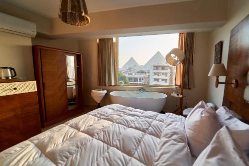 a bedroom with a bed and a bath tub and a window at prestige pyramids INN in Cairo