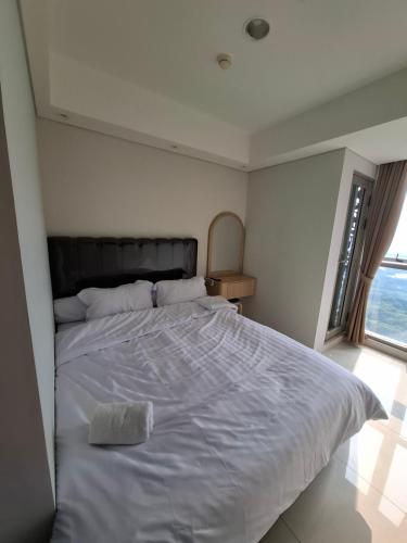 ein großes weißes Bett in einem Schlafzimmer mit Fenster in der Unterkunft Seaview gold coast pik bisnis room in Jakarta