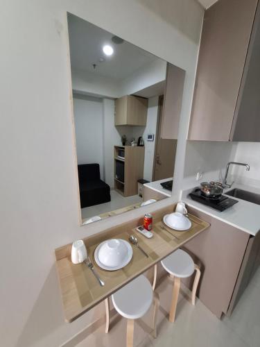 eine kleine Küche mit einem Tisch und vier Stühlen in der Unterkunft Seaview gold coast pik bisnis room in Jakarta