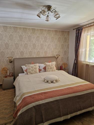 a bedroom with a bed with a stuffed animal on it at Casa Alina in Arpaşu de Sus