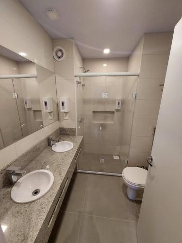 a bathroom with two sinks and a toilet at Lindo Flat no Serra Class com Piscina e Sauna in Canela