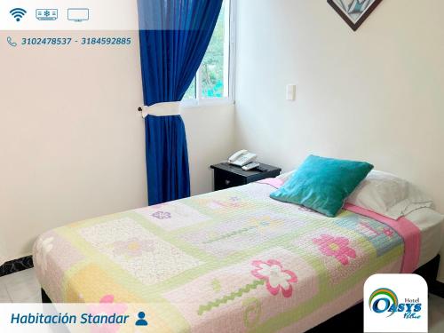 a bedroom with a bed with a quilt on it at Hotel Oasys Blue in Roldanillo