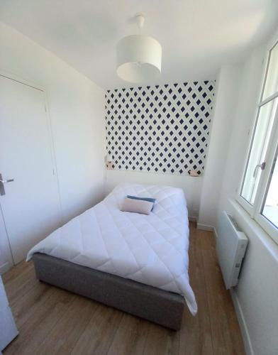une chambre avec un lit blanc dans une pièce dans l'établissement T2 au centre de Saint-Palais-Sur-Mer, à Saint-Palais-sur-Mer