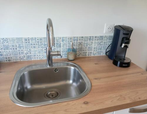 un fregadero con un grifo en una encimera de madera en T2 au centre de Saint-Palais-Sur-Mer, en Saint-Palais-sur-Mer