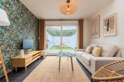 a living room with a couch and a tv at 3 bedroom house with garden, near tram in Mouvaux