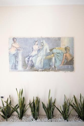 a painting hanging on a wall with plants at Residence O'Sole Mio Pompei in Pompei