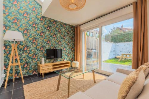 un salon avec une télévision et une table en verre dans l'établissement 3 bedroom house with garden, near tram, à Mouvaux