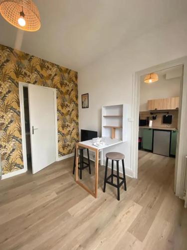 un salon avec une table et des chaises et une cuisine dans l'établissement Appartement charmant à Vichy, cosy, 23 m², près des thermes, à Vichy