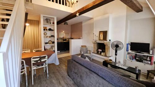 un salon avec un canapé et une salle à manger dans l'établissement Au calme en vieille ville - Proche lac - Ambiance esprit brocante, à Annecy