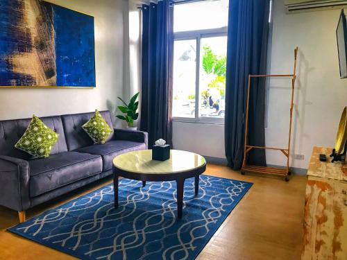a living room with a purple couch and a table at The Mansion Boutique Hotel in Mabalacat