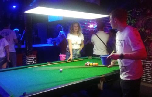een man en een vrouw die naast een pooltafel staan bij Moonland Bar and Hostel in Haad Rin