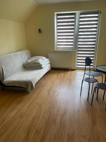 a bedroom with a bed and a wooden floor at DW Delfinek in Ustka