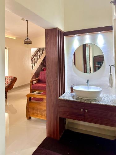un baño con lavabo y espejo en Spacious Beach Side House - Joyce Cottage Kerala, en Trivandrum