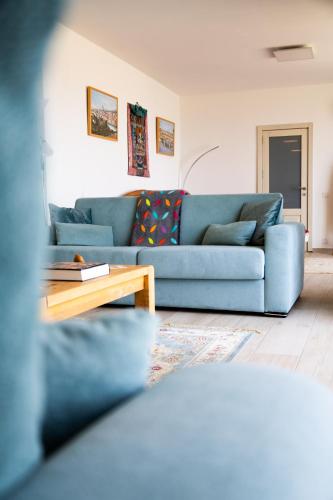 a living room with a blue couch and a coffee table at Elegant Apartments with Open Views in Xagħra